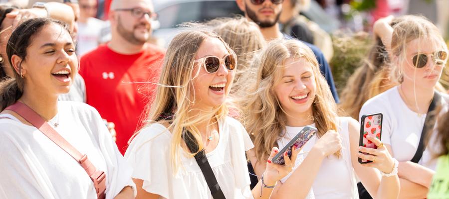 Group of students outside taking pictures with their phones